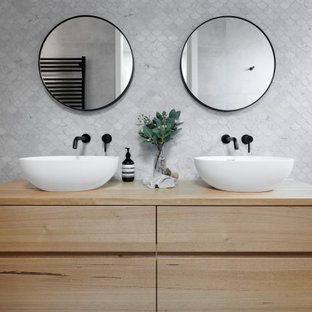 Photo of a large contemporary 3/4 bathroom in Melbourne with open cabinets, medium wood cabinets, gray tile, ceramic tile, white walls, a trough sink, wood benchtops, beige benchtops, a single vanity and a floating vanity.