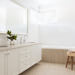 Design ideas for a large transitional 3/4 bathroom in Perth with recessed-panel cabinets, white cabinets, a drop-in tub, white tile, white walls, an undermount sink, beige floor, beige benchtops, a double vanity and a built-in vanity.