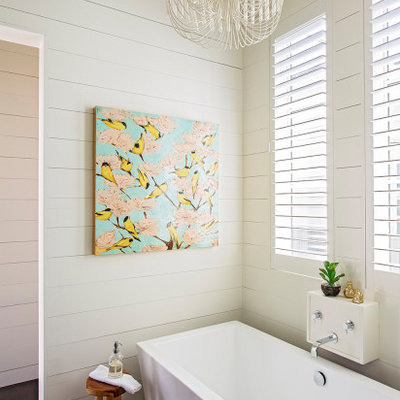 Example of a transitional dark wood floor, brown floor and shiplap wall freestanding bathtub design in Charleston with white walls