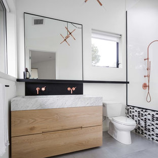 Mid-sized trendy master white tile and porcelain tile gray floor bathroom photo in Los Angeles with flat-panel cabinets, light wood cabinets, marble countertops, gray countertops, a two-piece toilet, white walls and a trough sink