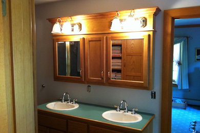 Imagen de cuarto de baño de estilo americano con armarios estilo shaker, puertas de armario de madera oscura, lavabo encastrado y encimeras turquesas