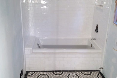 Imagen de cuarto de baño clásico de tamaño medio con bañera empotrada, combinación de ducha y bañera, baldosas y/o azulejos blancas y negros, baldosas y/o azulejos grises, baldosas y/o azulejos de cemento, paredes blancas, suelo con mosaicos de baldosas y aseo y ducha