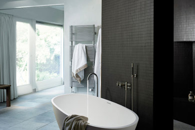 Diseño de cuarto de baño principal contemporáneo grande con bañera exenta, ducha abierta y suelo de cemento