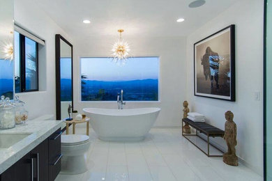 ロサンゼルスにあるコンテンポラリースタイルのおしゃれなマスターバスルーム (濃色木目調キャビネット、置き型浴槽、白い壁、アンダーカウンター洗面器、大理石の洗面台、白い床、磁器タイルの床) の写真