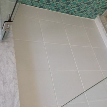 Multi colored glass tiles with a white ceramic shower floor Lancaster Ohio maste