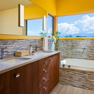 Esempio di una grande stanza da bagno padronale design con ante lisce, vasca da incasso, piastrelle multicolore, pareti gialle, pavimento in vinile, lavabo sottopiano, top in superficie solida, piastrelle a listelli, ante in legno scuro, doccia ad angolo e pavimento beige