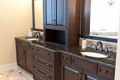 Bathroom - large traditional master bathroom idea in Other with raised-panel cabinets, dark wood cabinets, beige walls, an undermount sink and granite countertops
