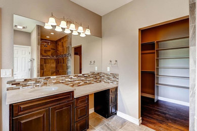 This is an example of a medium sized classic ensuite bathroom in Denver with raised-panel cabinets, dark wood cabinets, a built-in bath, a corner shower, beige tiles, brown tiles, porcelain tiles, brown walls, porcelain flooring, a submerged sink, granite worktops and beige floors.