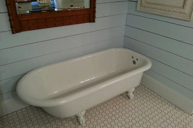 Ornate master porcelain tile claw-foot bathtub photo in Dallas with blue walls