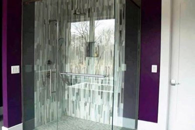 Foto de cuarto de baño contemporáneo con ducha empotrada, baldosas y/o azulejos grises, azulejos en listel, paredes púrpuras, suelo de baldosas de porcelana, suelo gris y ducha con puerta con bisagras