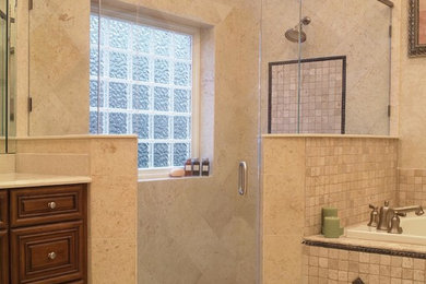 Example of a large transitional master beige tile and porcelain tile porcelain tile and beige floor corner shower design in Richmond with beige walls, a hinged shower door, raised-panel cabinets, medium tone wood cabinets and quartz countertops
