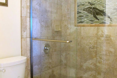 ハワイにある中くらいなトロピカルスタイルのおしゃれなバスルーム (浴槽なし) (オーバーカウンターシンク、落し込みパネル扉のキャビネット、濃色木目調キャビネット、御影石の洗面台、アルコーブ型シャワー、一体型トイレ	、マルチカラーの壁、セラミックタイルの床) の写真
