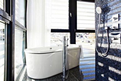 Foto på ett funkis badrum, med ett fristående badkar och klinkergolv i porslin