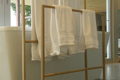 Foto de cuarto de baño principal minimalista de tamaño medio con bañera exenta, paredes beige, suelo de cemento y suelo gris