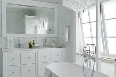 パースにある中くらいなコンテンポラリースタイルのおしゃれなマスターバスルーム (白いキャビネット、置き型浴槽、白いタイル、白い壁、大理石の床) の写真