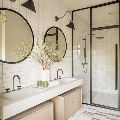 Farmhouse 3/4 white tile walk-in shower photo in New York with furniture-like cabinets, light wood cabinets, an integrated sink, a hinged shower door and beige countertops