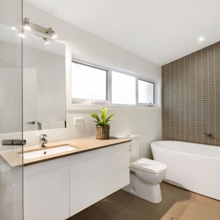 Inspiration for a large contemporary master bathroom in Sydney with a freestanding tub, white walls, porcelain floors, quartzite benchtops, beige floor, beige benchtops, flat-panel cabinets, white cabinets, brown tile and an undermount sink.