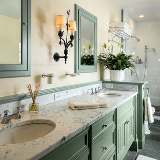 Modelo de cuarto de baño de estilo de casa de campo con armarios con paneles empotrados, puertas de armario verdes, ducha empotrada y paredes beige