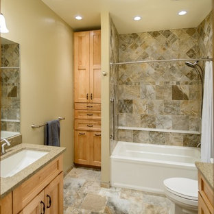 Immagine di una stanza da bagno per bambini country con lavabo sottopiano, ante con riquadro incassato, ante in legno chiaro, top in granito, vasca ad alcova, doccia doppia, WC a due pezzi, piastrelle multicolore, piastrelle in pietra, pareti marroni e pavimento in gres porcellanato