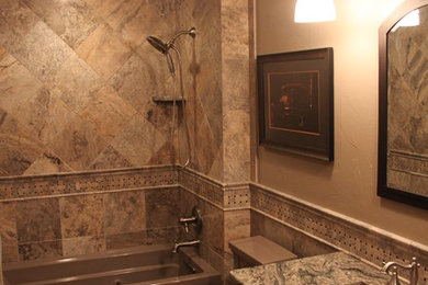Mid-sized elegant multicolored tile and stone tile travertine floor alcove bathtub photo in Chicago with an undermount sink, dark wood cabinets, granite countertops, a one-piece toilet, beige walls and raised-panel cabinets