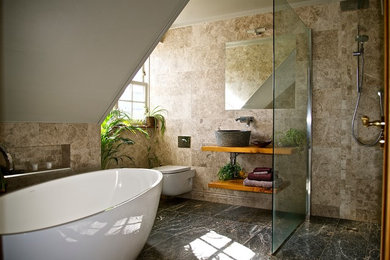 Example of a trendy master beige tile bathroom design in Other with a vessel sink, open cabinets, medium tone wood cabinets, wood countertops and a wall-mount toilet
