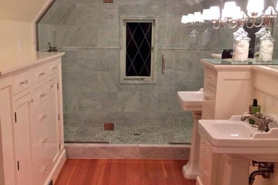 Esempio di una stanza da bagno classica con lavabo a colonna, consolle stile comò, ante bianche, doccia doppia, piastrelle grigie e pavimento in legno massello medio