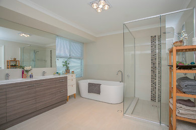 パースにある広いおしゃれなマスターバスルーム (置き型浴槽、コーナー設置型シャワー、ベージュの壁) の写真