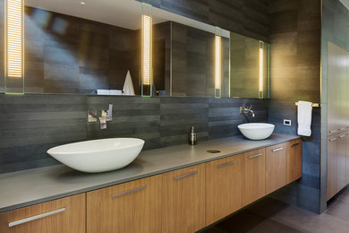 Inspiration for a contemporary family bathroom in Essex with flat-panel cabinets, light wood cabinets, grey tiles, grey walls, ceramic flooring, a trough sink and grey floors.