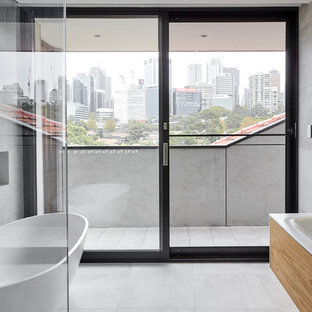 Contemporary 3/4 bathroom in Sydney with flat-panel cabinets, medium wood cabinets, a freestanding tub, gray tile, white tile, mosaic tile, grey walls, an integrated sink, grey floor and white benchtops.