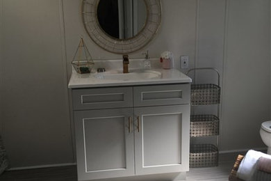 Mid-sized elegant vinyl floor and gray floor bathroom photo in Other with shaker cabinets, gray cabinets, gray walls, an undermount sink and marble countertops