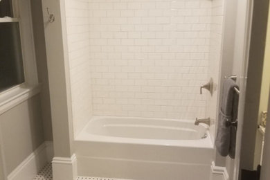 Modelo de cuarto de baño tradicional de tamaño medio con bañera empotrada, combinación de ducha y bañera, paredes grises, suelo de azulejos de cemento, aseo y ducha, suelo multicolor, ducha con cortina, sanitario de dos piezas y baldosas y/o azulejos de cemento