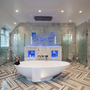 This is an example of a large contemporary wet room bathroom in Buckinghamshire with a freestanding bath, grey tiles, grey floors and a hinged door.