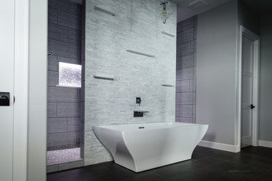 Inspiration pour une douche en alcôve principale minimaliste avec une baignoire indépendante, un carrelage gris, des carreaux de porcelaine, un mur gris, un sol en carrelage de porcelaine, un sol noir et aucune cabine.