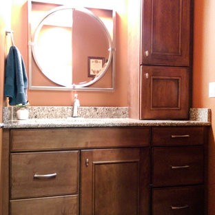 Inspiration for a small timeless 3/4 beige floor bathroom remodel in St Louis with brown cabinets, raised-panel cabinets, pink walls, an undermount sink and granite countertops