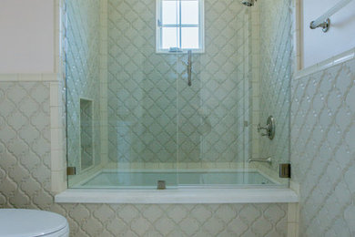 Foto de cuarto de baño clásico renovado con puertas de armario blancas, combinación de ducha y bañera, sanitario de una pieza, baldosas y/o azulejos de porcelana, paredes blancas y suelo de baldosas de porcelana