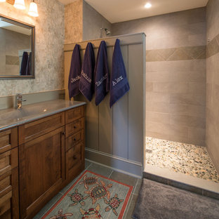 Alcove shower - traditional pebble tile floor alcove shower idea in Boston with an integrated sink, recessed-panel cabinets, gray walls and dark wood cabinets