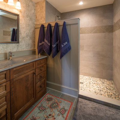 Alcove shower - traditional pebble tile floor alcove shower idea in Boston with an integrated sink, recessed-panel cabinets, gray walls and dark wood cabinets