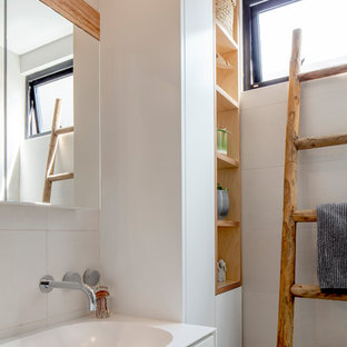 Inspiration for a contemporary bathroom in Sydney with flat-panel cabinets, white cabinets, white tile, white walls, a console sink and white benchtops.