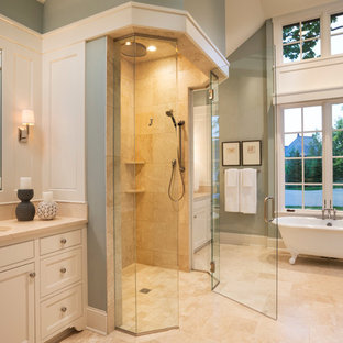 Example of a small french country master beige tile and limestone tile limestone floor and beige floor bathroom design in Minneapolis with an undermount sink, recessed-panel cabinets, white cabinets, limestone countertops, blue walls, a hinged shower door and beige countertops