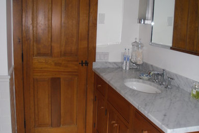 Imagen de cuarto de baño tradicional pequeño con armarios estilo shaker, puertas de armario de madera clara, paredes blancas, suelo de mármol, aseo y ducha, lavabo bajoencimera y encimera de mármol