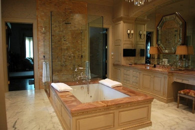 Bathroom - large mediterranean master beige tile and stone tile marble floor bathroom idea in Houston with raised-panel cabinets, light wood cabinets, beige walls, an undermount sink and marble countertops