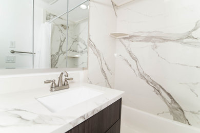 Inspiration for a traditional bathroom in Salt Lake City with flat-panel cabinets, black cabinets, an alcove bath, a shower/bath combination, white tiles, marble tiles, white walls, a submerged sink, marble worktops, a shower curtain and white worktops.