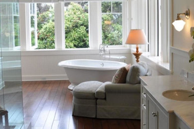 Inspiration for a coastal medium tone wood floor freestanding bathtub remodel in Los Angeles with an undermount sink, recessed-panel cabinets, white cabinets and white walls