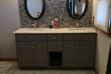 Imagen de cuarto de baño tradicional renovado con armarios con paneles con relieve, puertas de armario grises, baldosas y/o azulejos en mosaico, suelo de baldosas de porcelana y lavabo bajoencimera