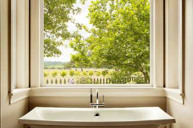 Foto de cuarto de baño clásico de tamaño medio con bañera exenta y paredes beige