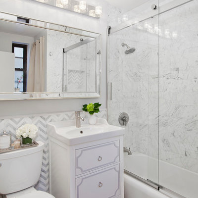 Elegant white tile medium tone wood floor bathroom photo in New York with furniture-like cabinets, white cabinets, a two-piece toilet, white walls and a console sink