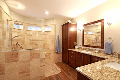 Example of a large transitional master beige tile and limestone tile limestone floor and beige floor bathroom design in Richmond with shaker cabinets, medium tone wood cabinets, beige walls and granite countertops