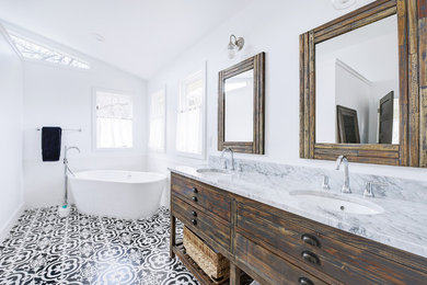 Large transitional master white tile and subway tile ceramic tile and multicolored floor freestanding bathtub photo in Denver with flat-panel cabinets, distressed cabinets, a one-piece toilet, white walls, an undermount sink, marble countertops and white countertops