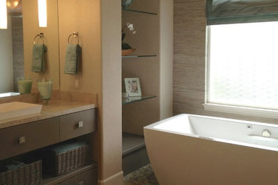 Diseño de cuarto de baño principal actual grande con lavabo encastrado, armarios con paneles lisos, puertas de armario grises, encimera de piedra caliza, bañera exenta, paredes blancas y suelo de madera en tonos medios