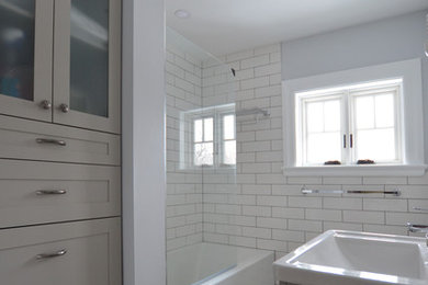Small trendy 3/4 white tile and porcelain tile porcelain tile and multicolored floor bathroom photo in Ottawa with shaker cabinets, gray cabinets, a wall-mount toilet, gray walls, a drop-in sink and a hinged shower door